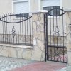 Kőburkolat és kovácsoltvas kerítés